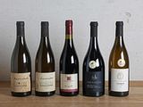plusieurs bouteilles de vin sont alignées sur une table en bois