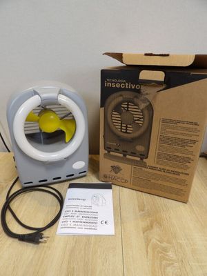un ventilateur posé sur une table à côté d'une boîte