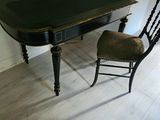 a black table and a chair in the corner of a room