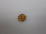 a gold coin sitting on top of a white surface
