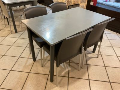 tables and chairs in a restaurant with a window in the background