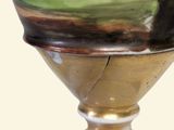 a vase with a painting on it sitting on a table