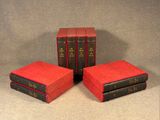 three red books sitting on top of each other on a table