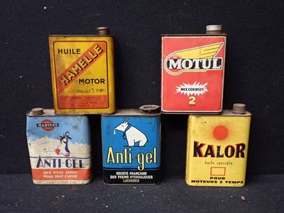 quatre bidons d'huile moteur sont alignés sur une surface noire