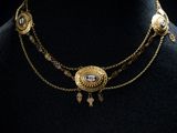 un gros plan sur un mannequin portant un collier en or orné d'un œil bleu