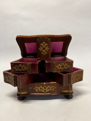 une petite boîte en bois surmontée de trois tiroirs