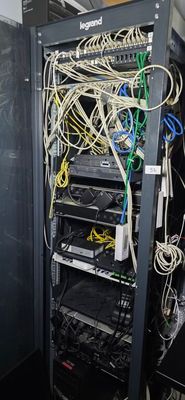 a rack of wires in a room with a blackboard on the wall