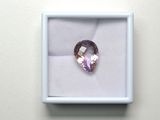 un gros plan sur un diamant rose dans une boîte blanche