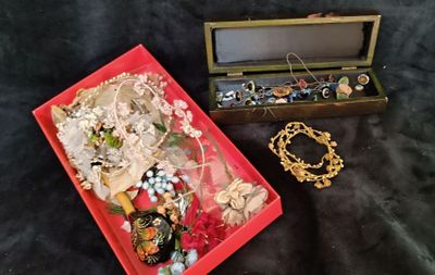 a red box filled with jewelry on a black cloth