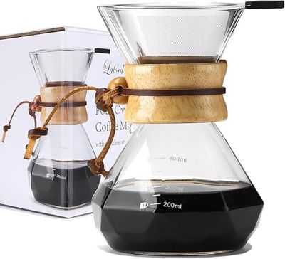 une cafetière en verre avec une poignée en bois, à côté d'une boîte de café