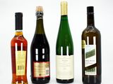 three bottles of wine sit next to each other on a white surface