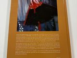 the back cover of a book with a picture of a woman ' s hand holding a red purse