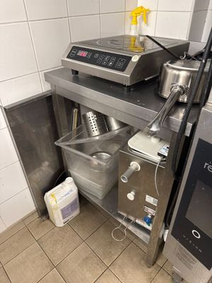 une petite cuisine équipée d'une cuisinière, d'un évier et d'autres appareils électroménagers