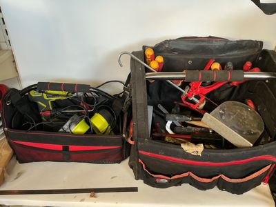 deux valises remplies d'outils, posées sur une étagère