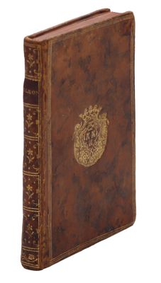un vieux livre avec un emblème en or sur la couverture
