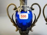 a blue glass vase with a gold handle and a label on it