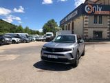un SUV garé devant un immeuble devant lequel sont garées des voitures