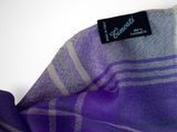 the purple and grey scarf is folded on a white surface