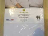 the bed sheet is white and has a woman sleeping on it