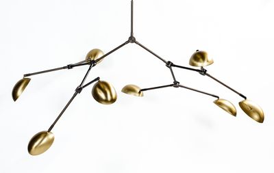 un gros plan d'un lustre en métal orné de feuilles dorées