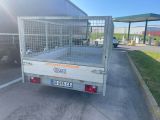 un camion équipé d'une cage à l'arrière, garé sur un parking