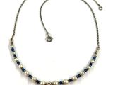 collier composé de perles bleues et blanches et d'un pendentif en forme de larme
