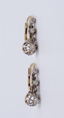deux paires de boucles d'oreilles en or et diamants sur fond blanc