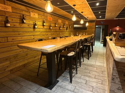 une longue table en bois avec des tabourets dans un restaurant