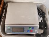 a digital scale sitting in a container on a table