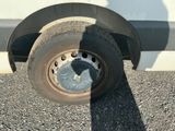 a shadow of a person standing next to a truck tire