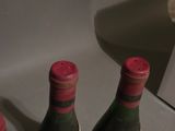 two bottles of wine sitting next to each other on a counter