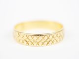 gros plan d'une bague en or sur une surface blanche