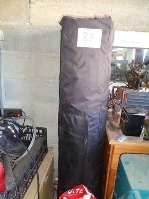un grand sac noir posé sur une table, à côté d'une pile de cartons