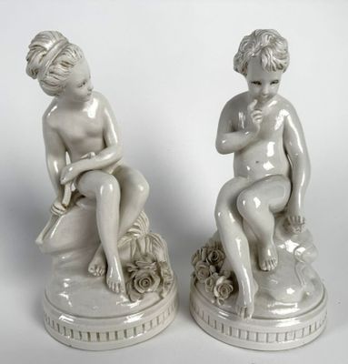 paire de figurines en porcelaine blanche représentant un garçon et une fille assis sur un rocher
