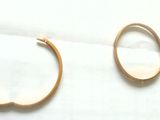 deux paires de boucles d'oreilles créoles en or posées sur un morceau de papier