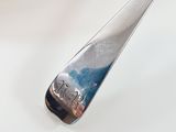 a silver spoon with a picture on it sitting on a table