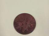 un petit bout de papier sur lequel figure une pièce de monnaie marron