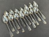six silver spoons are lined up in a row on a table
