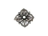 a close up of a flower shaped broochle on a white background