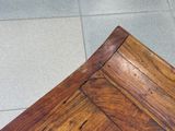a close up view of a wooden table on a tiled floor