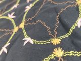 embroidery on a black shirt with yellow and pink flowers on it