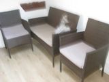 three wicker chairs and a couch in the corner of a room