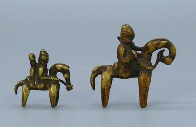 pair of bronze figurines of a man on a horse and a woman sitting on a horse