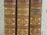 trois vieux livres sont alignés sur une table