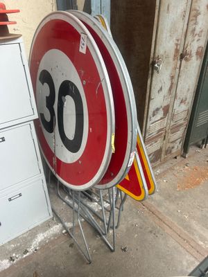 un panneau de limitation de vitesse rouge et blanc à côté d'un panneau blanc et rouge