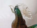 a glass bird that is sitting on top of a rock