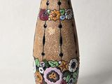 un vase marron orné de fleurs sur fond blanc