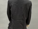 a mannequin wearing a black suit with gold trimmings