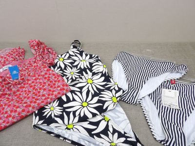 several women ' s swimsuits are laid out on a couch