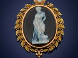 une image représentant une broche sur laquelle figure une femme tenant une perle